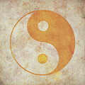 Yin-yang symbol in gold on weathered beige background